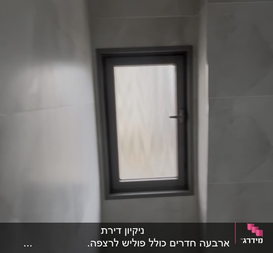 חלון קטן בחדר אמבטיה עם קירות אפורים